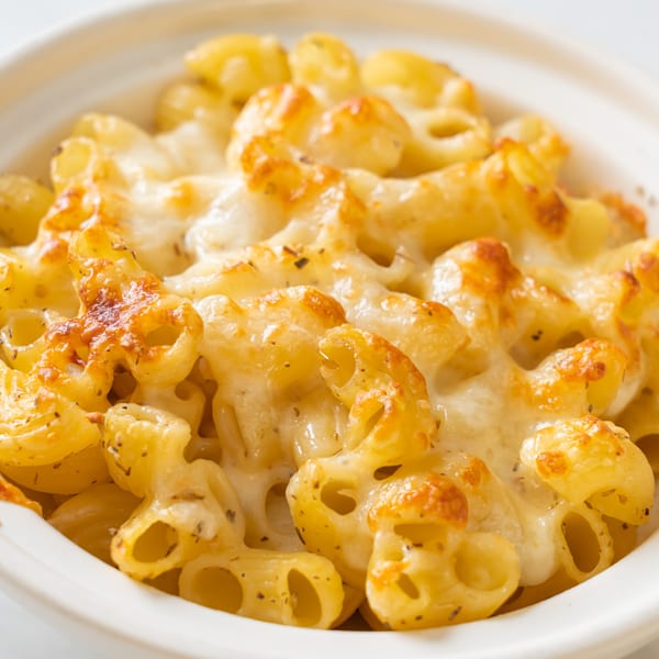 Close-up of DMac & Wings' baked macaroni and cheese with melted, bubbly cheese and herbs.