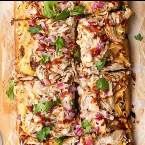 Close-up of DMac & Wings' BBQ chicken flatbread, topped with red onions and cilantro.